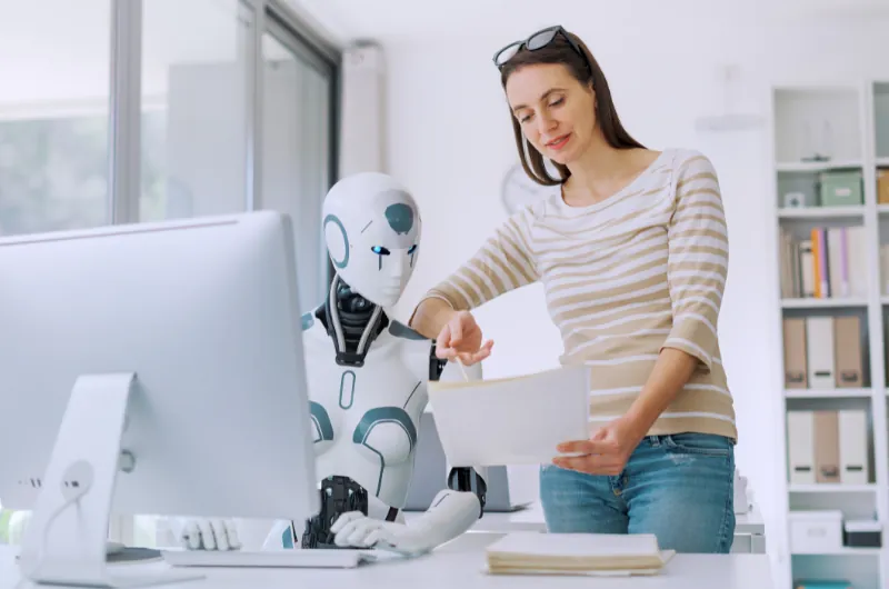 Woman collaborating with an AI robot assistant at a desk while reviewing SEO documents
